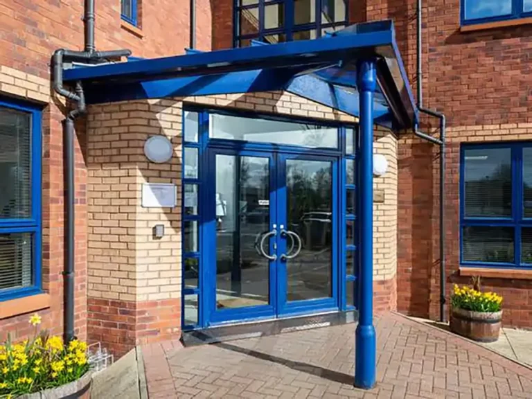 Entrance of the E-Centre business hub in Alloa, Clackmannanshire, with modern blue-framed doors leading to serviced receptions and vibrant surroundings